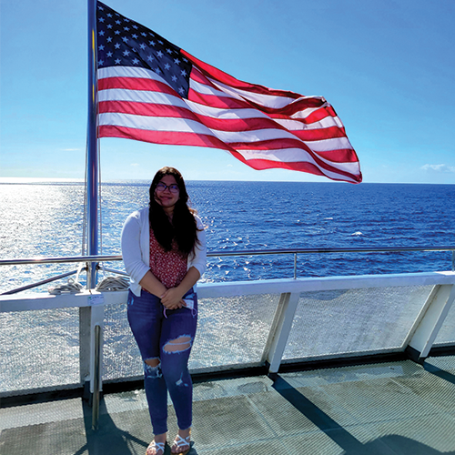 girl standing in front of an American flag